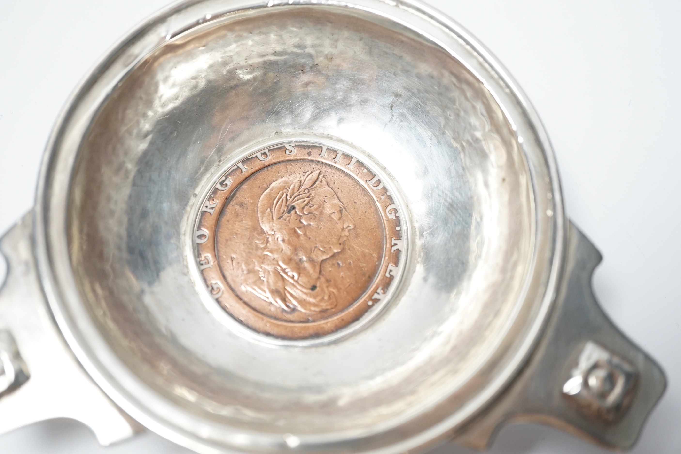 A George V Arts & Craft silver tri-form dish, by Albert Edwards Jones, Birmingham, 1913, the base with inset George III 1797 cartwheel penny, 10.8cm.